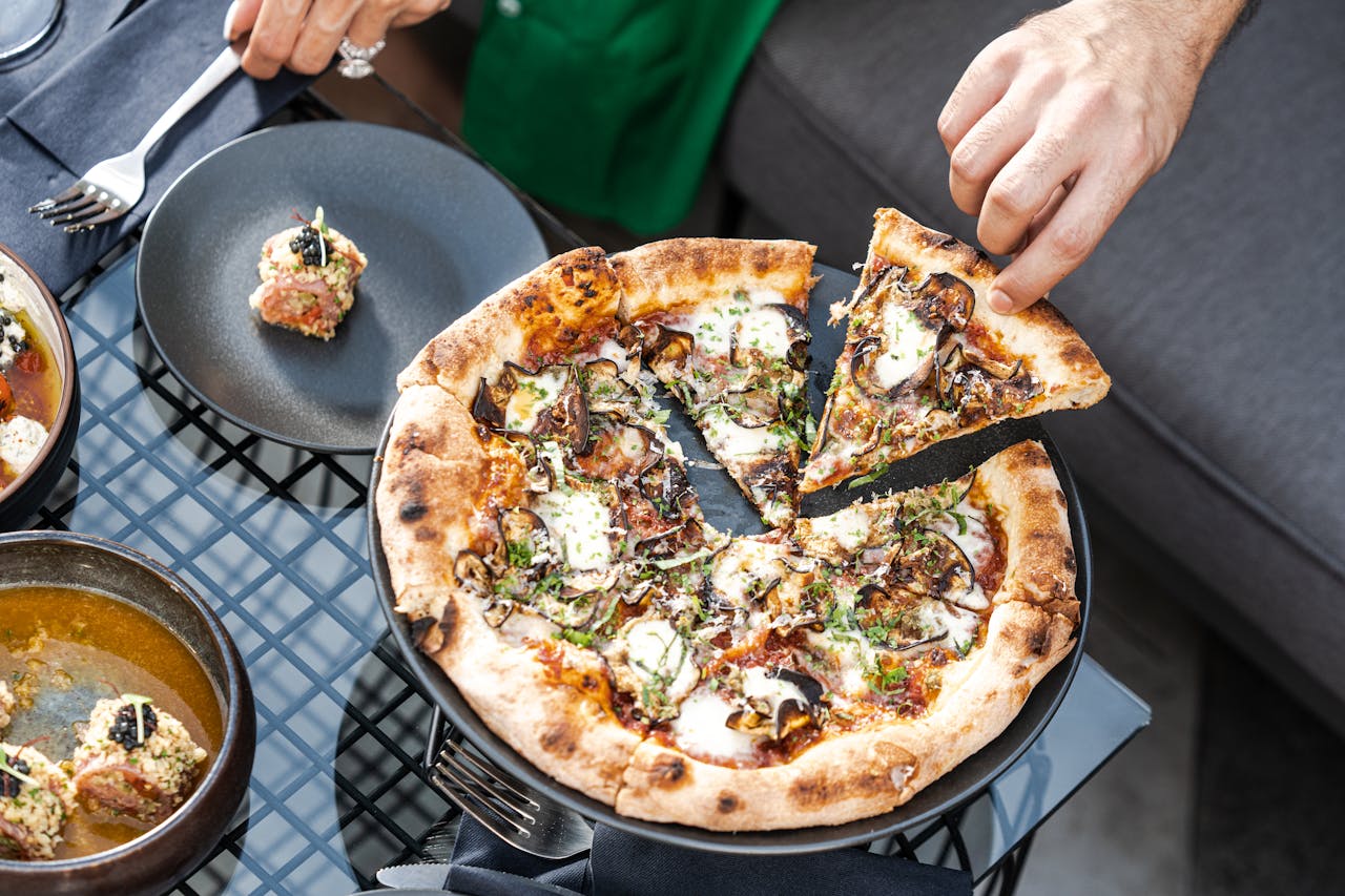 Delicious gourmet pizza with mushrooms, herbs, and mozzarella cheese being served on a dining table in Dubai.