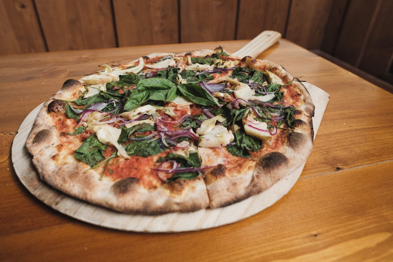 Delicious veggie pizza on a wooden board, showcasing fresh ingredients and rustic charm.